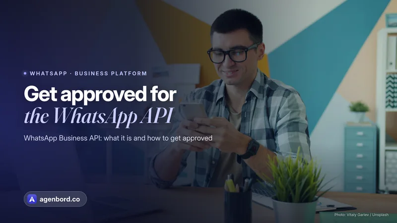 A man smiling at his phone at his desk. Headline: Get approved for the WhatsApp API
